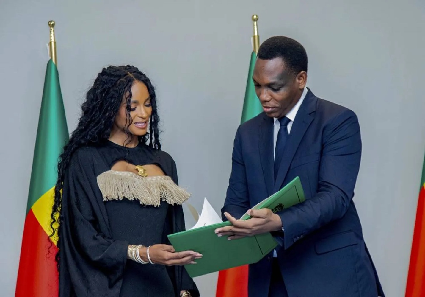 Figure 2: Yvon Detchenou, Benin's Minister of Justice and Legislation, presents citizenship documents to singer Ciara at a ceremony in Cotonou.